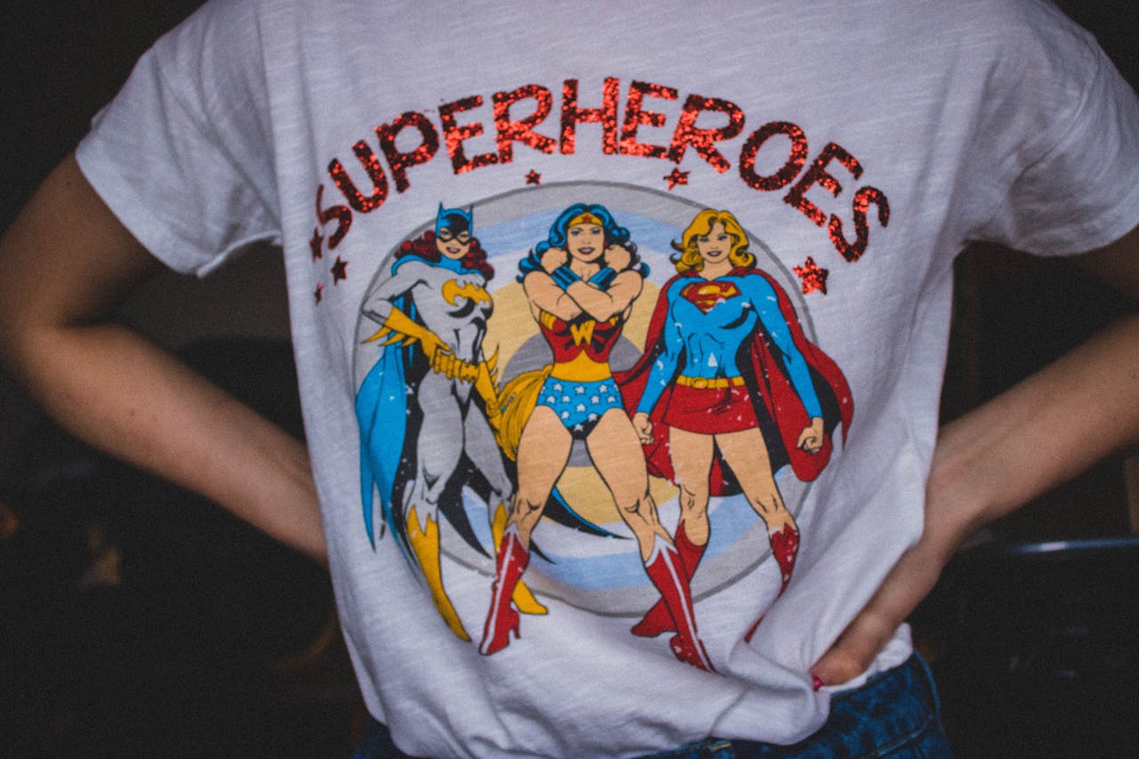 Services A vibrant superhero themed t-shirt featuring female comic characters in a bold design.